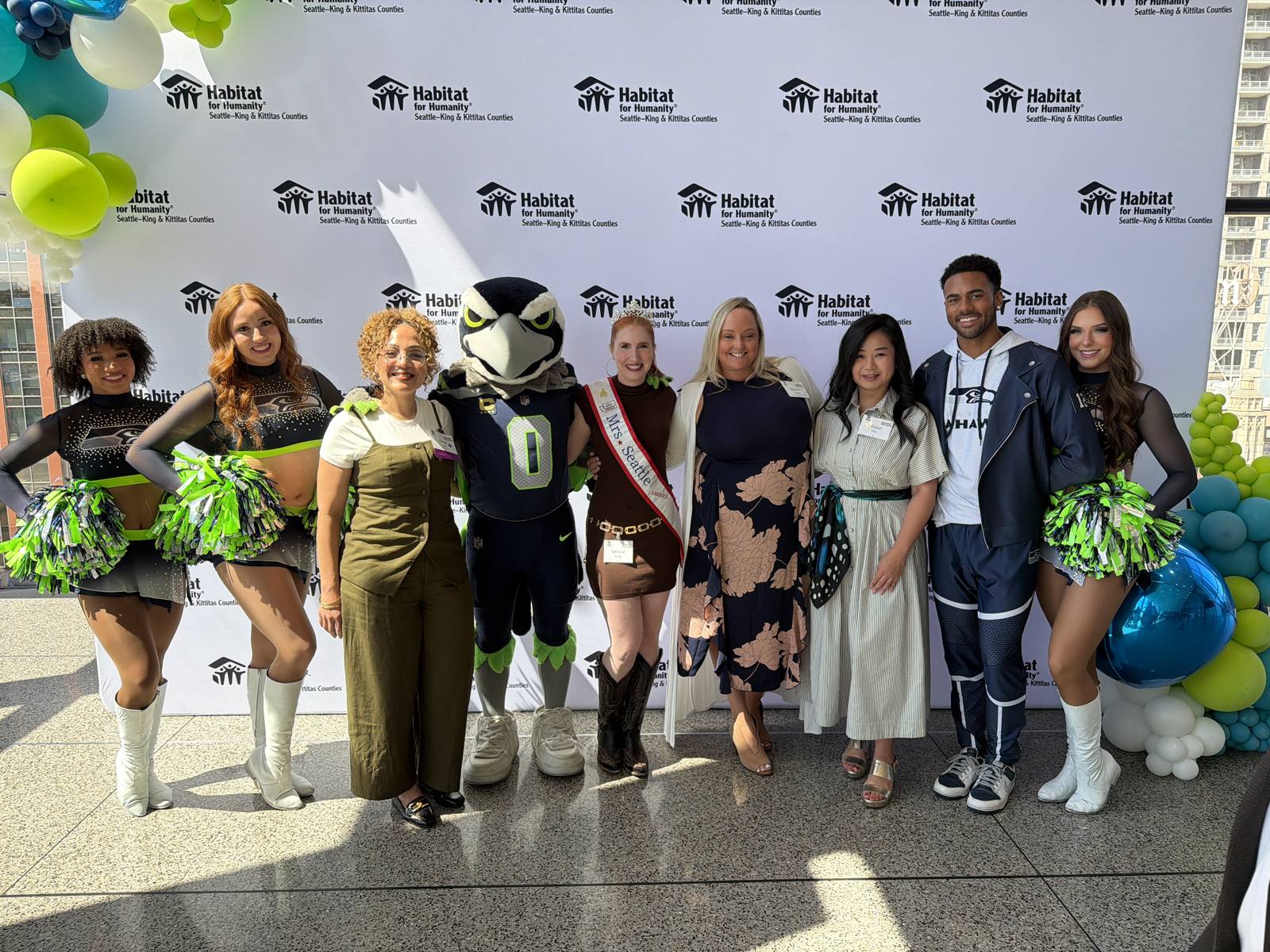 Clients and partners at a branded step-and-repeat event backdrop